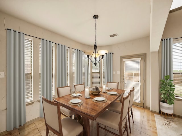 dining space with a wealth of natural light, visible vents, an inviting chandelier, and light tile patterned floors