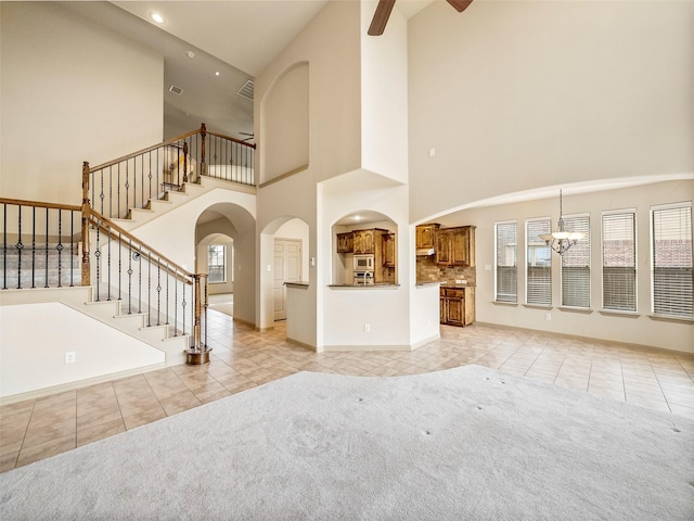 unfurnished living room featuring stairs, light colored carpet, visible vents, and light tile patterned floors