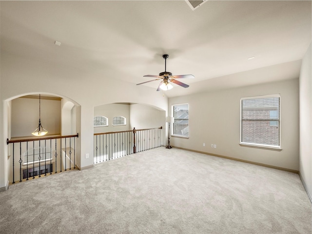 carpeted spare room with ceiling fan and baseboards