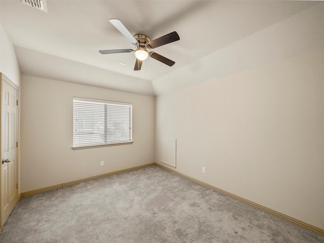 empty room with light carpet, visible vents, baseboards, ceiling fan, and vaulted ceiling