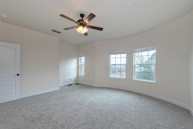 carpeted empty room featuring visible vents, ceiling fan, and baseboards