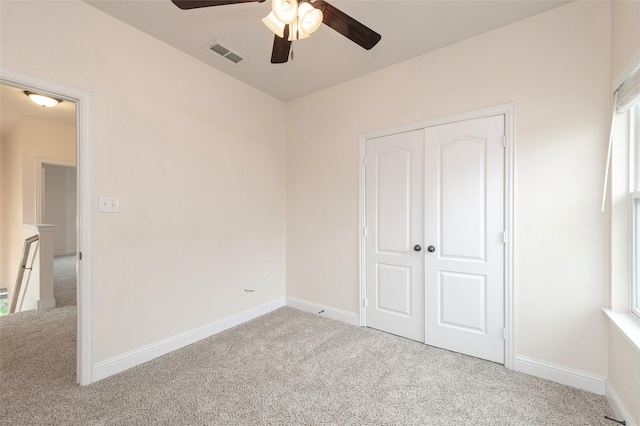 unfurnished bedroom featuring carpet, a closet, visible vents, and baseboards