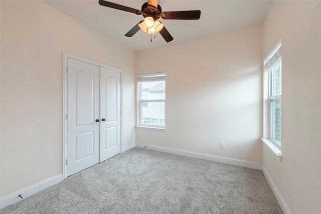 unfurnished bedroom with carpet floors, a ceiling fan, baseboards, and a closet