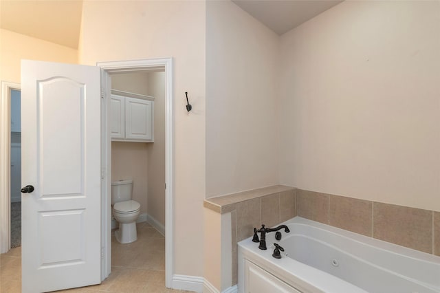 bathroom featuring baseboards, a jetted tub, toilet, and tile patterned floors