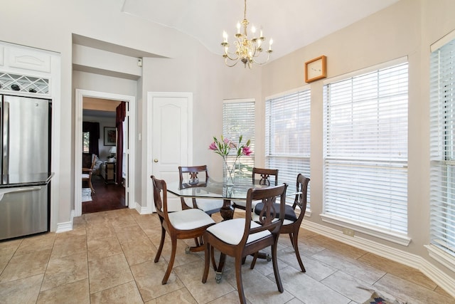 dining area featuring lofted ceiling, light tile patterned floors, baseboards, and a notable chandelier