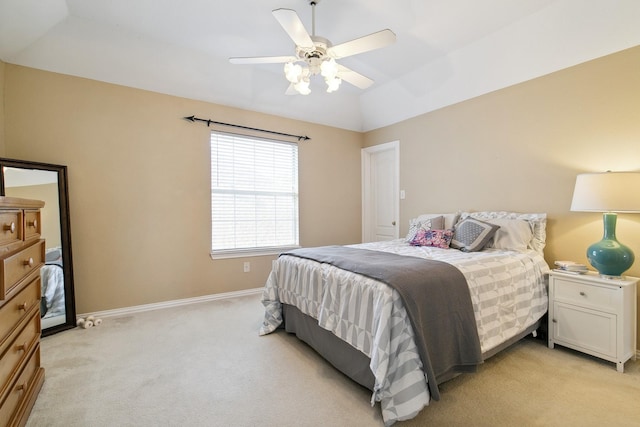 bedroom with a ceiling fan, light carpet, vaulted ceiling, and baseboards