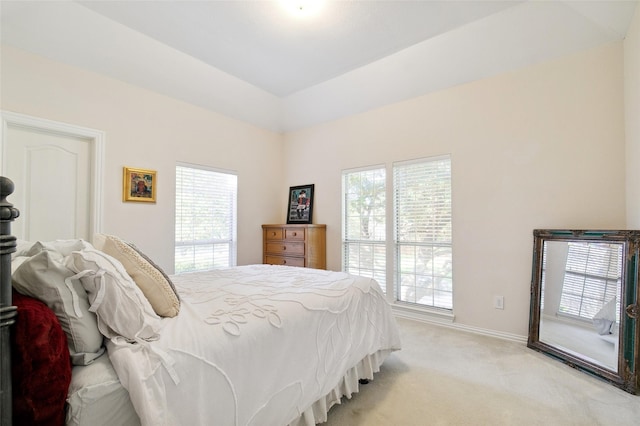 bedroom with light colored carpet and baseboards