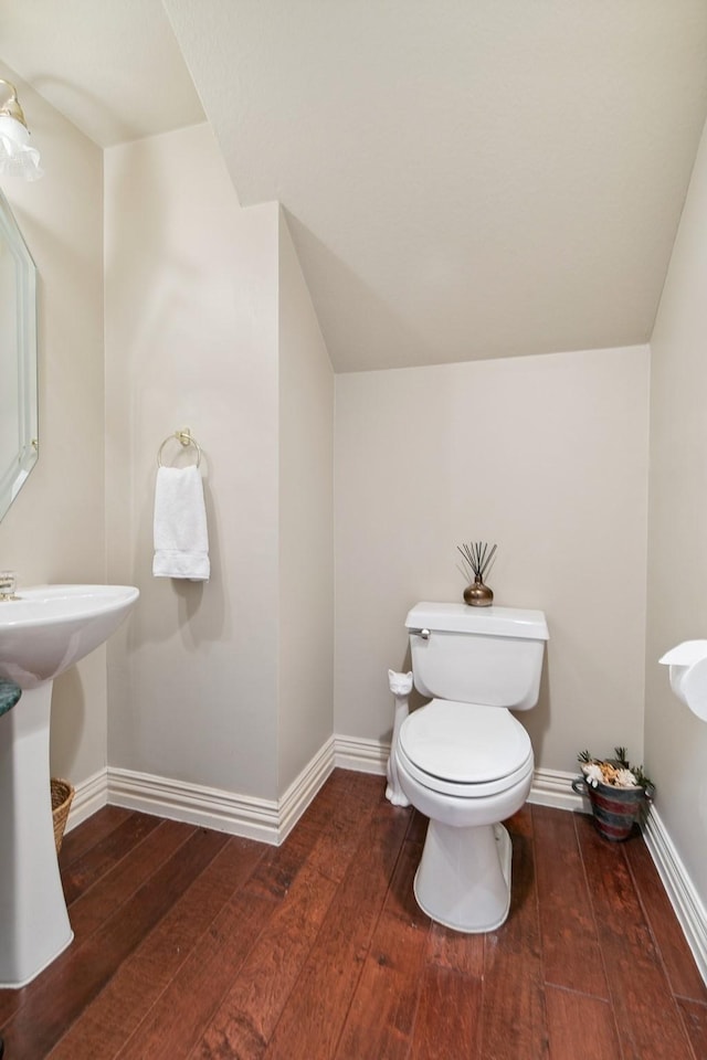 bathroom featuring toilet, baseboards, vaulted ceiling, and hardwood / wood-style floors