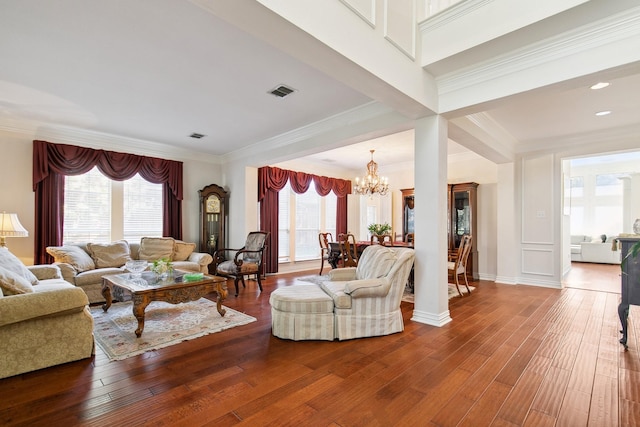 living room with wood finished floors, visible vents, and crown molding