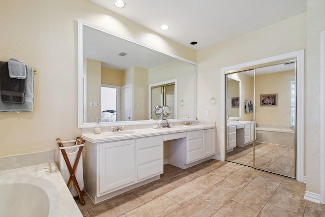 full bath with visible vents, a sink, a bath, and double vanity