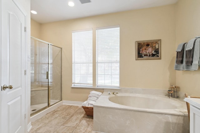 bathroom featuring a shower stall, a bath, and recessed lighting