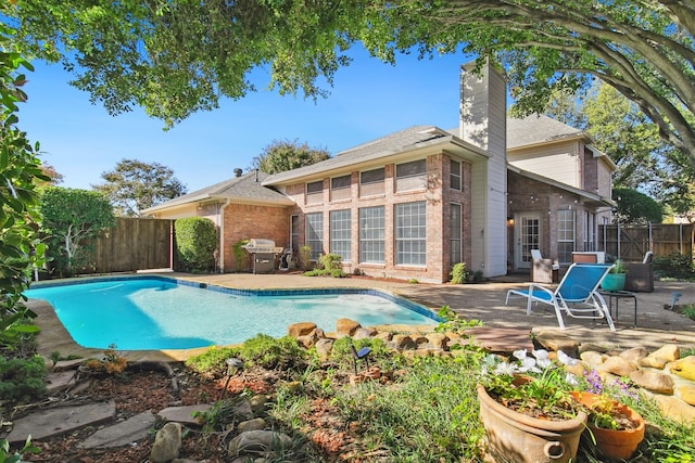 view of swimming pool with a fenced in pool, a patio area, a grill, and a fenced backyard