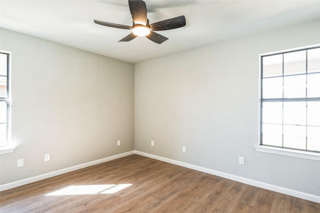 empty room with ceiling fan, baseboards, and wood finished floors