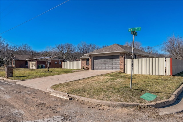 view of front facade featuring an attached garage, brick siding, fence, concrete driveway, and a front yard