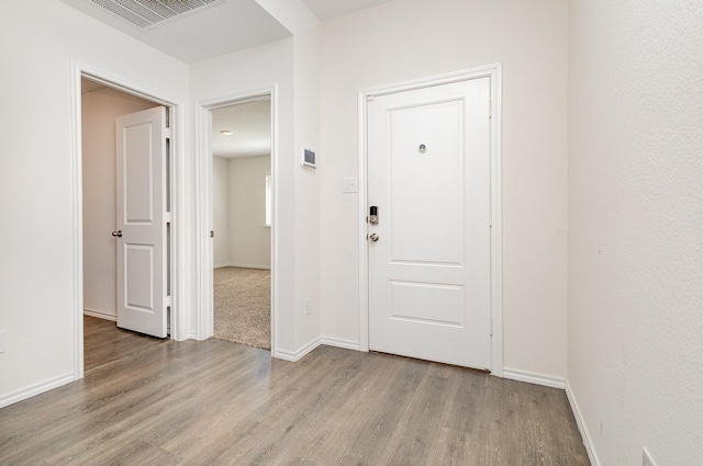 foyer entrance featuring light wood-style floors, baseboards, and visible vents