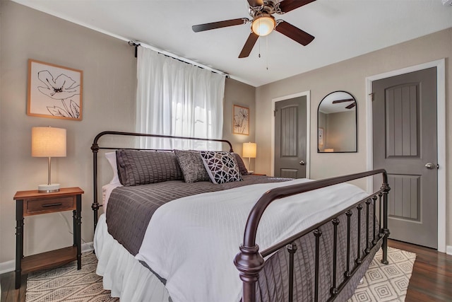 bedroom with ceiling fan, wood finished floors, and baseboards