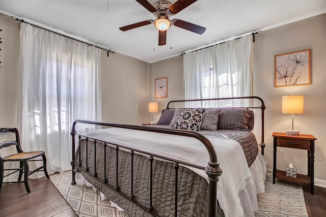 bedroom featuring multiple windows, ceiling fan, and wood finished floors