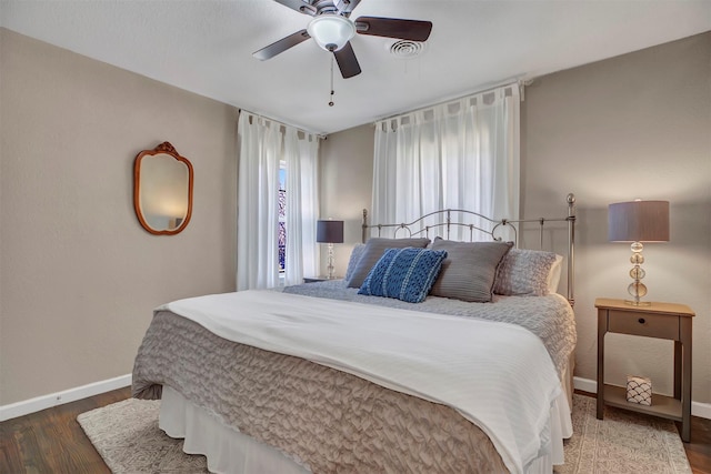 bedroom featuring visible vents, ceiling fan, baseboards, and wood finished floors