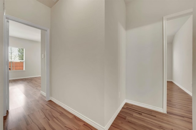 hallway with light wood-style floors and baseboards