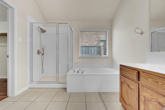 bathroom with a stall shower, vaulted ceiling, vanity, tile patterned flooring, and a bath