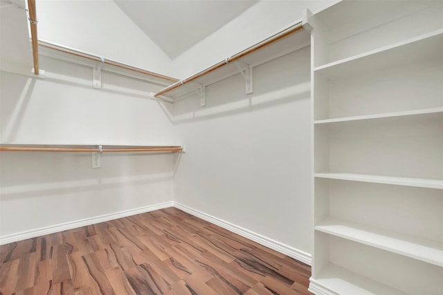 walk in closet featuring lofted ceiling and wood finished floors