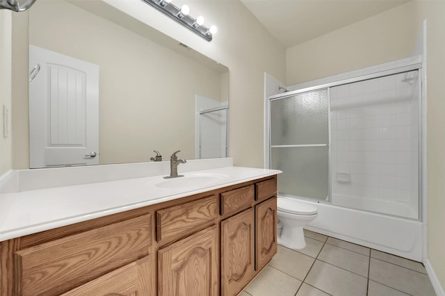 full bathroom featuring toilet, bath / shower combo with glass door, vanity, and tile patterned floors