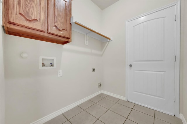 clothes washing area with washer hookup, cabinet space, hookup for an electric dryer, light tile patterned flooring, and baseboards