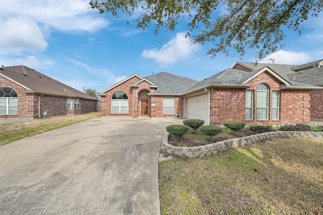 view of front facade with an attached garage, brick siding, a shingled roof, driveway, and a front yard