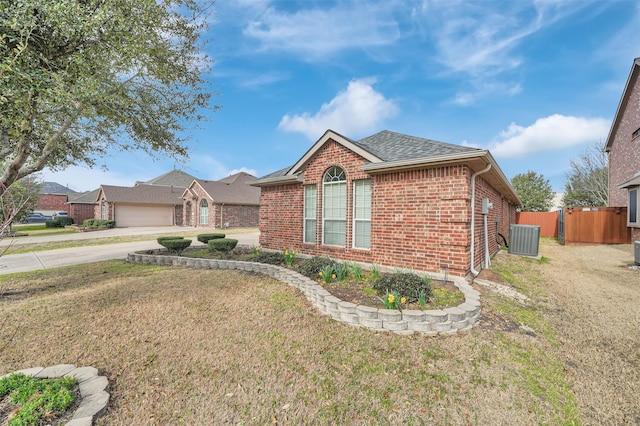 single story home with brick siding, a shingled roof, concrete driveway, fence, and a front yard