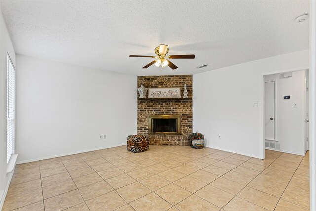 unfurnished living room featuring visible vents, a ceiling fan, light tile patterned flooring, and a fireplace