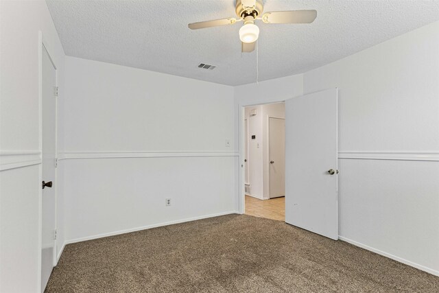 unfurnished bedroom with visible vents, baseboards, ceiling fan, carpet floors, and a textured ceiling