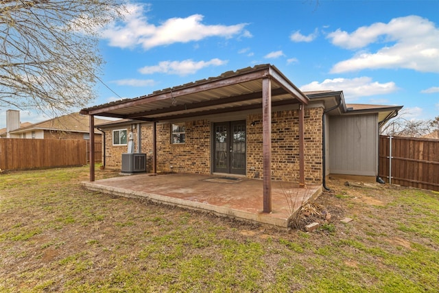 back of property featuring brick siding, a fenced backyard, and a patio