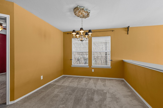 spare room featuring baseboards, carpet flooring, and an inviting chandelier