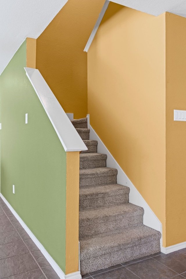 stairway featuring baseboards and tile patterned floors