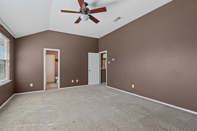 unfurnished room with baseboards, visible vents, a ceiling fan, vaulted ceiling, and carpet floors