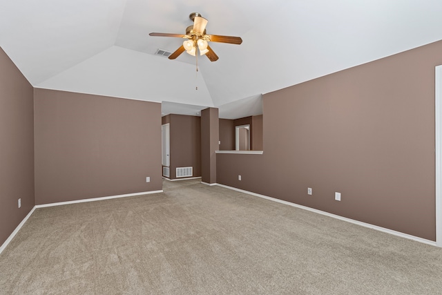 carpeted spare room with visible vents, vaulted ceiling, baseboards, and ceiling fan