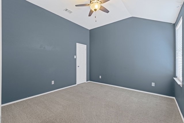 carpeted empty room featuring vaulted ceiling, ceiling fan, visible vents, and baseboards