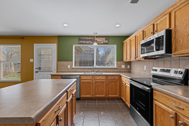 kitchen featuring stainless steel appliances, recessed lighting, decorative backsplash, a sink, and tile patterned flooring