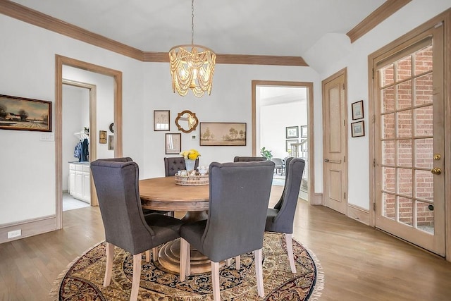 dining room with baseboards, light wood-style flooring, a chandelier, and crown molding