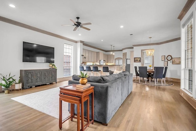 living area with baseboards, ornamental molding, light wood-type flooring, and recessed lighting