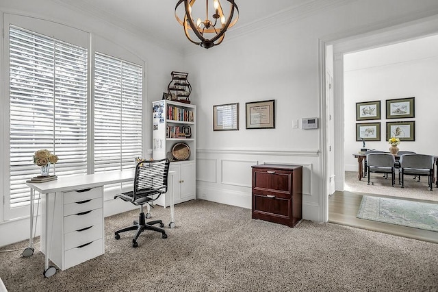 home office with light colored carpet, a wainscoted wall, crown molding, a decorative wall, and a notable chandelier