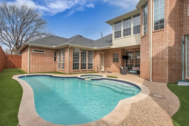 view of pool featuring a pool with connected hot tub, a patio area, and a fenced backyard