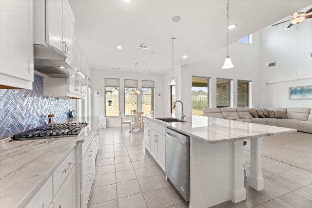 kitchen featuring stainless steel appliances, visible vents, open floor plan, a sink, and under cabinet range hood