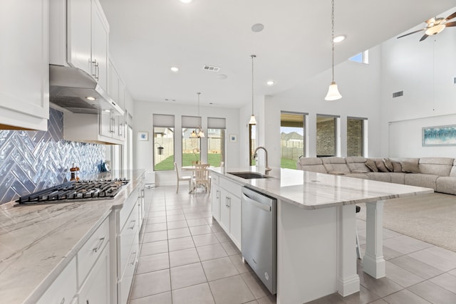 kitchen featuring visible vents, appliances with stainless steel finishes, a sink, light tile patterned floors, and under cabinet range hood
