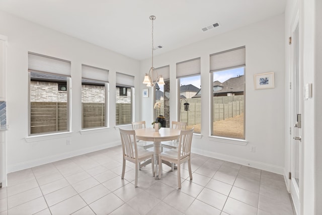 dining space featuring visible vents, a notable chandelier, baseboards, and light tile patterned floors