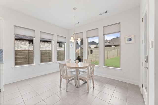 dining room with light tile patterned flooring, baseboards, visible vents, and an inviting chandelier