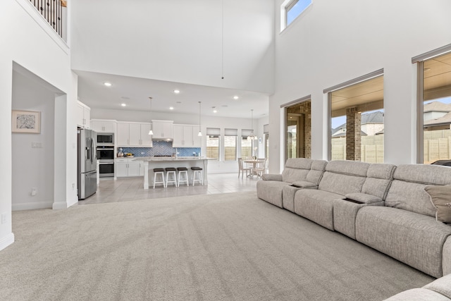 living room with recessed lighting, plenty of natural light, baseboards, and light colored carpet