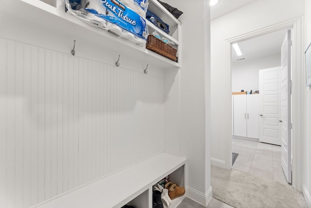 mudroom with light colored carpet, baseboards, and light tile patterned floors