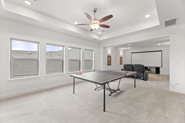 game room featuring baseboards, visible vents, a tray ceiling, and light colored carpet