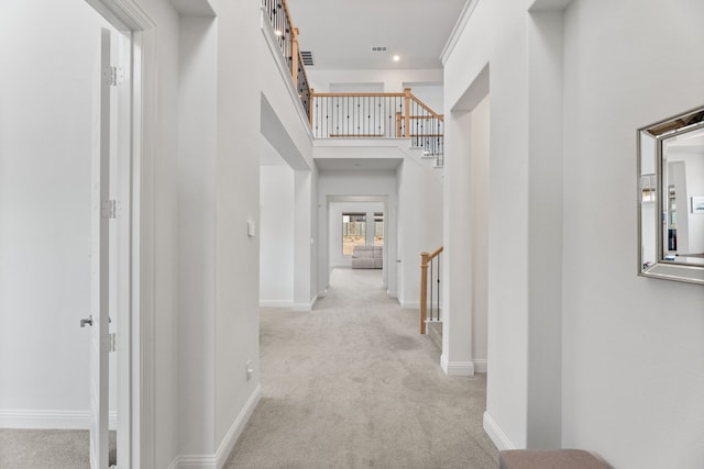 hall with carpet floors, a high ceiling, stairway, and baseboards